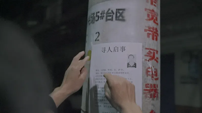 Long Daibing points to a missing person poster he put up around his village in Chongqing, September 2020
