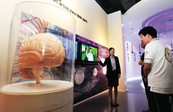 A young Chinese student listens to an educational TV show about brain health at the Shanghai youth center.