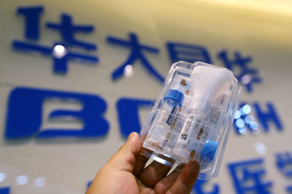 An employee holds up a blood sampling package at a gene-testing company in Kunming.
