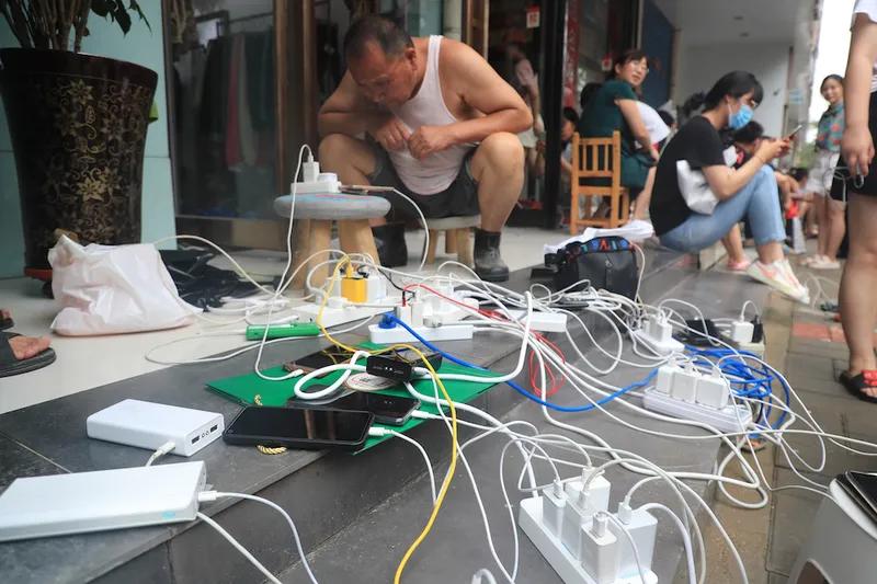 Zhengzhou residents attempt to keep devices charged while being displaced the disaster (VCG)