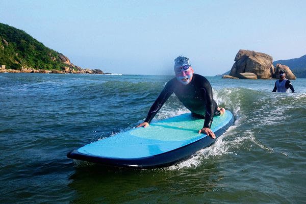 A disabled athlete learning how to ride the waves of Hainan.