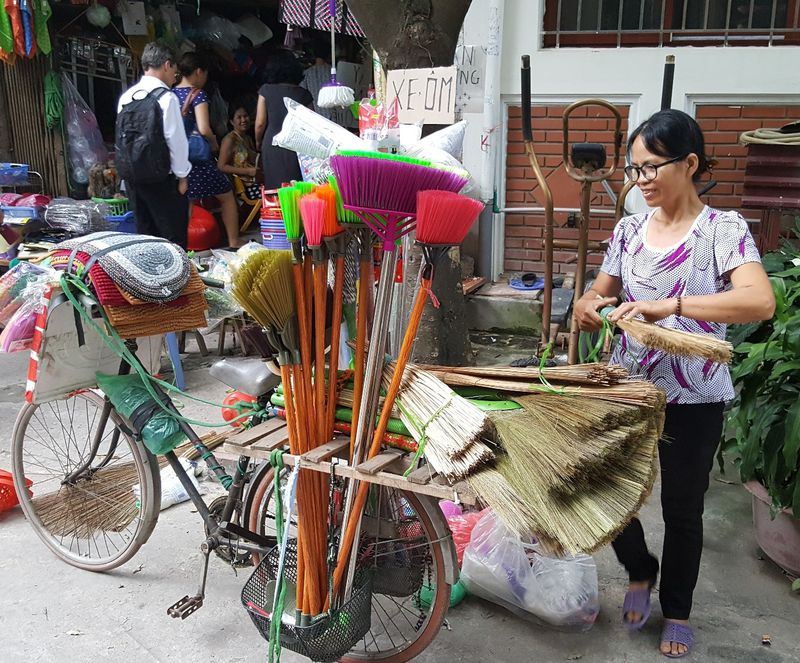A bicycle vendor in Hanoi, Vietnam selling a wide variety of brooms. (Devpolicy)