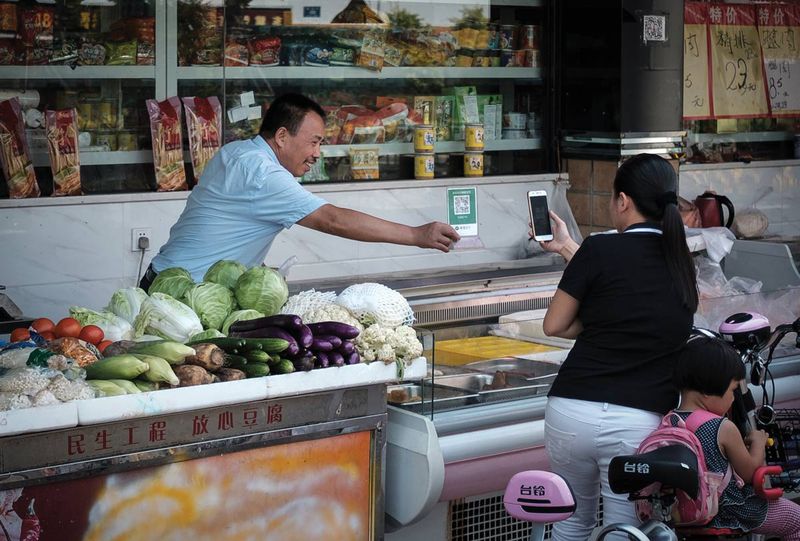 A customer pays with WeChat in a food market in Jiangsu, a testament to the ubiquity of electronic payment in China