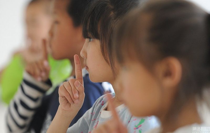 Principal Guo says that most of the kids are orphans, and that many don't even know their real names or what it's like to have a mother. In the picture below, they learn how to sign "mom." (Shanghaiist)
