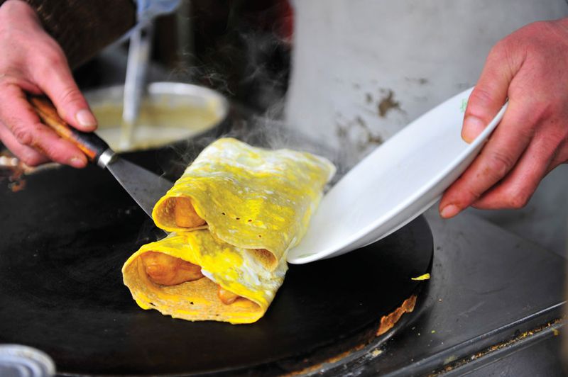 A Tianjin jianbing guozi wrapped around fried dough stick