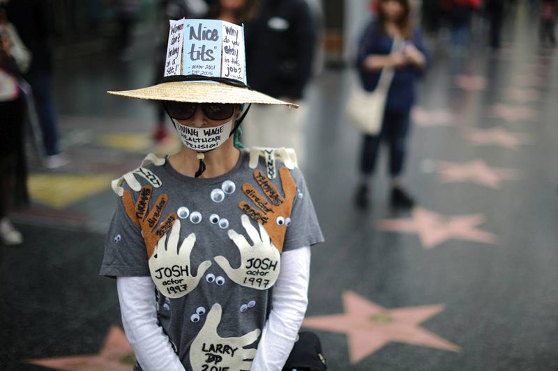 A woman wears an outfit with the names of all the men in Hollywood who have sexually harassed her, at a protest march for sexual assault survivors and their allies in Hollywood in November, 2017