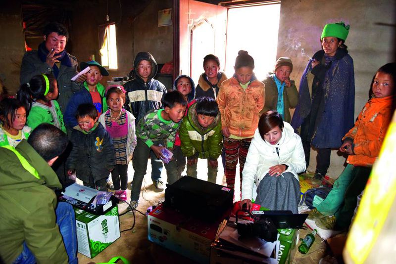 In Abingluogu county, Sichuan province, volunteers from Shenzhen bring toys and candy to the left-behind children in the village during the Spring Festival