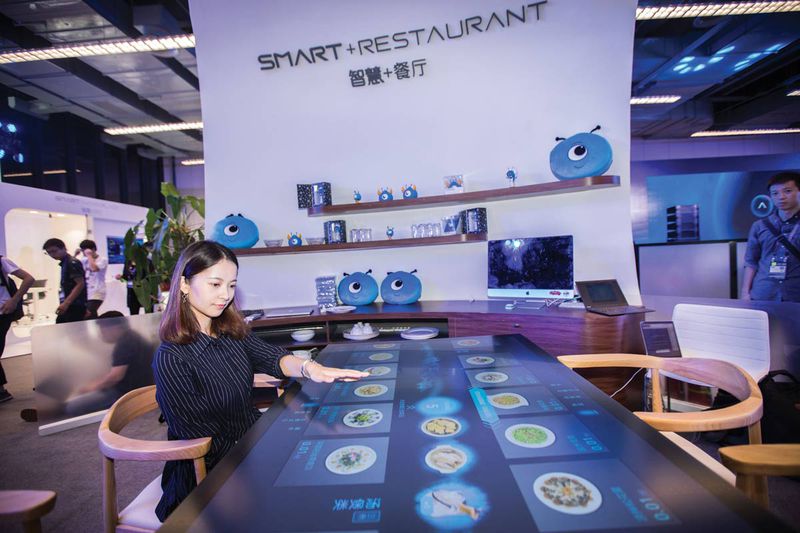 A visitor browses the menu of Alibaba's "Smart+Restaurant" system, in an exhibition in Hangzhou in October 2017