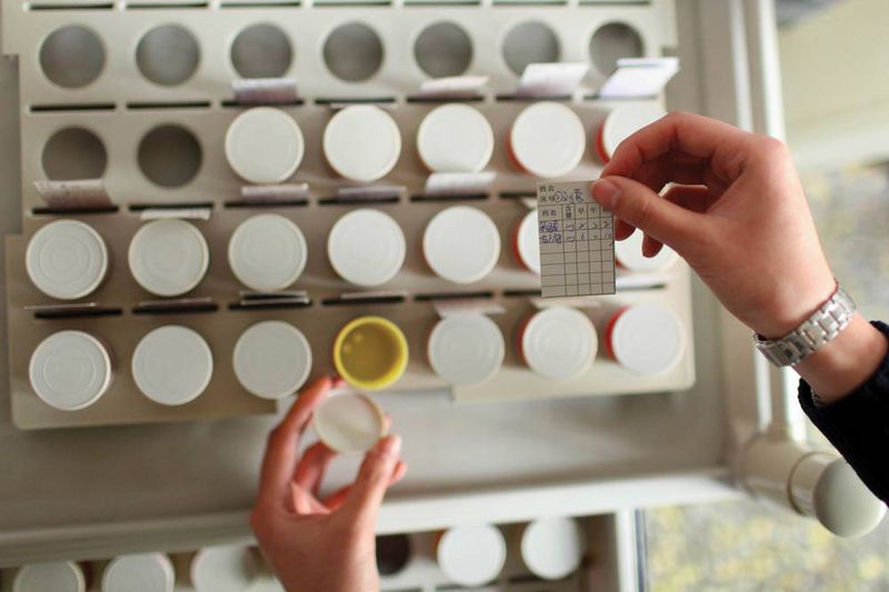 A nurse matches patients' names to their daily dosage of medicine at a mental hospital in Liaoning province