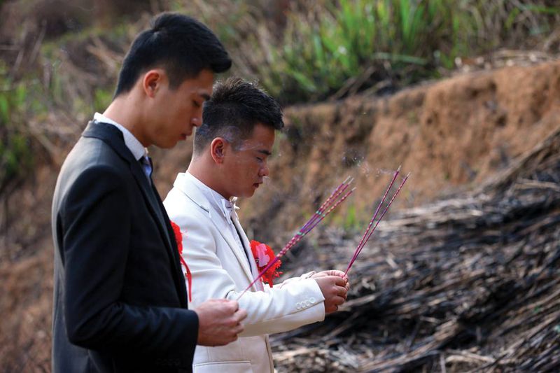Lu Zhong (right) and Liu Wangqiang became the first gay couple to publicly hold a wedding ceremony in Fujian province in 2012. As part of the ceremony, the couple paid their respects at the grave of Lu's late father.