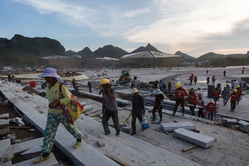 Migrant workers leave the Cultural Park's construction site after work