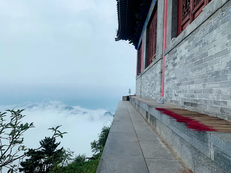 A view looking down the mountain from a Daoist temple with incense drying on the ledge.