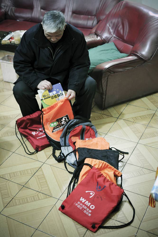 A grandfather packs up one of his grandchild's seven after-school enrichment textbooks